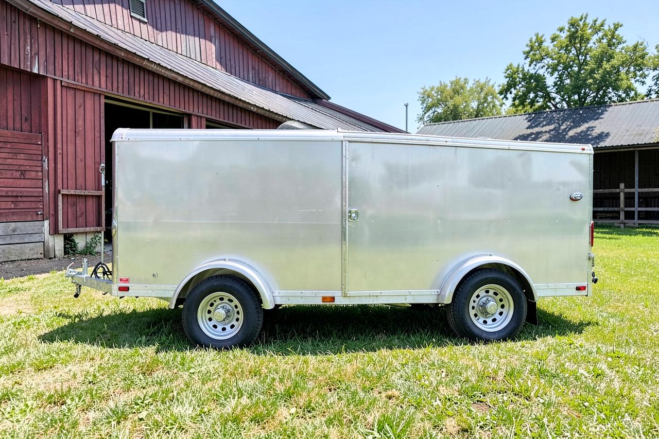 Aluminium Krismar trailer voor twee paarden naast een stal